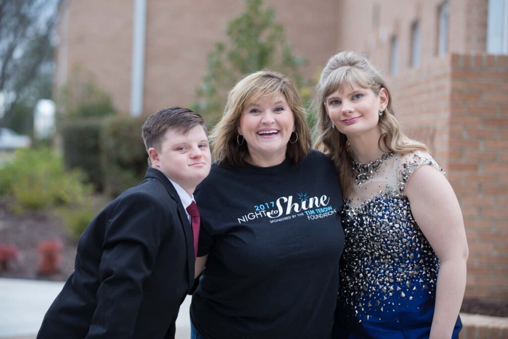 Night to Shine volunteer with two prom goers